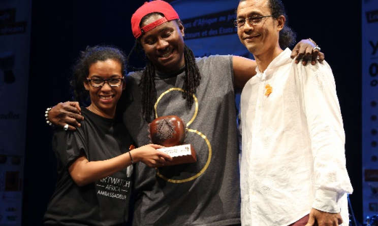 Didier Awadi receives his award from Arterial Network’s Diana Ramarohetra and George Camille. Photo: David Durbach