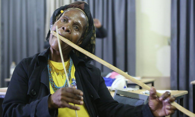 This is an image of a woman playing the umakhweyana.