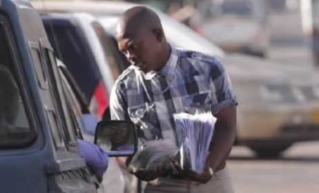 A vendor sells pirated music to motorists on the streets of Harare. Photo: The Herald