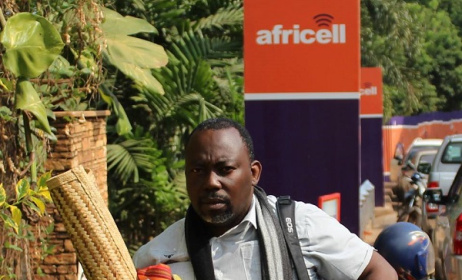 Richard Kawesa who protested in chains, on a mat outside the Africell ofiices. Photo:Chimpreports.com